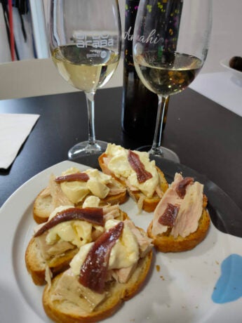 Pintxos de Bonito del norte, mayonesa y anchoas, acompañados de dos copas de vino blanco