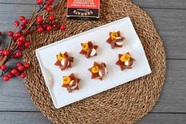 Canapé navideño de membrillo, queso crema, anchoa y mango