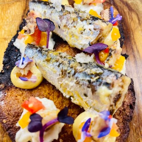 Galleta de pan con sardinillas en aceite de pimentón