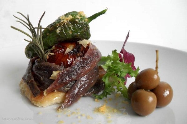 Montadito de anchoas del Cantábrico de Conservas Serrats en cama de hojaldre, verduras asadas y escamas de sal al limón