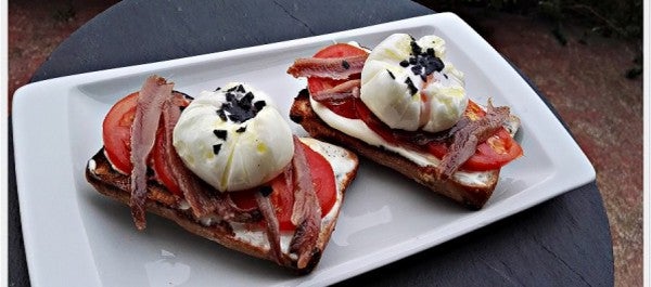 Tosta de pan de nueces con anchoa y huevo poche